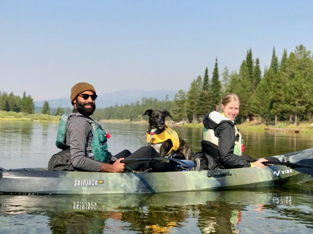 couple kayaking with a dog